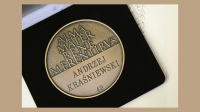 Zdjęcie przedstawia medal z łacińska sentencją: ALMA MATER BENE MERENTIBVS i nazwiskiem Prof. Andrzeja Kraśniewskiego
